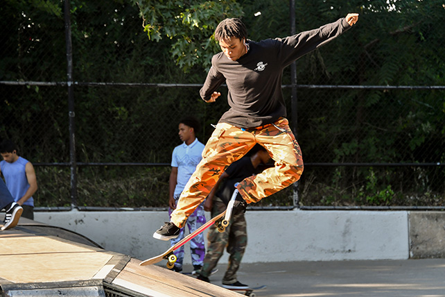 A skater performing a trick in the air off a ramp.