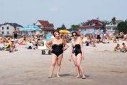 Two woman posing near the water. 