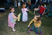 Chilren practice jousting among their peers on the lawn. 