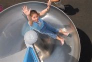 A girl tries out the playground's slide 